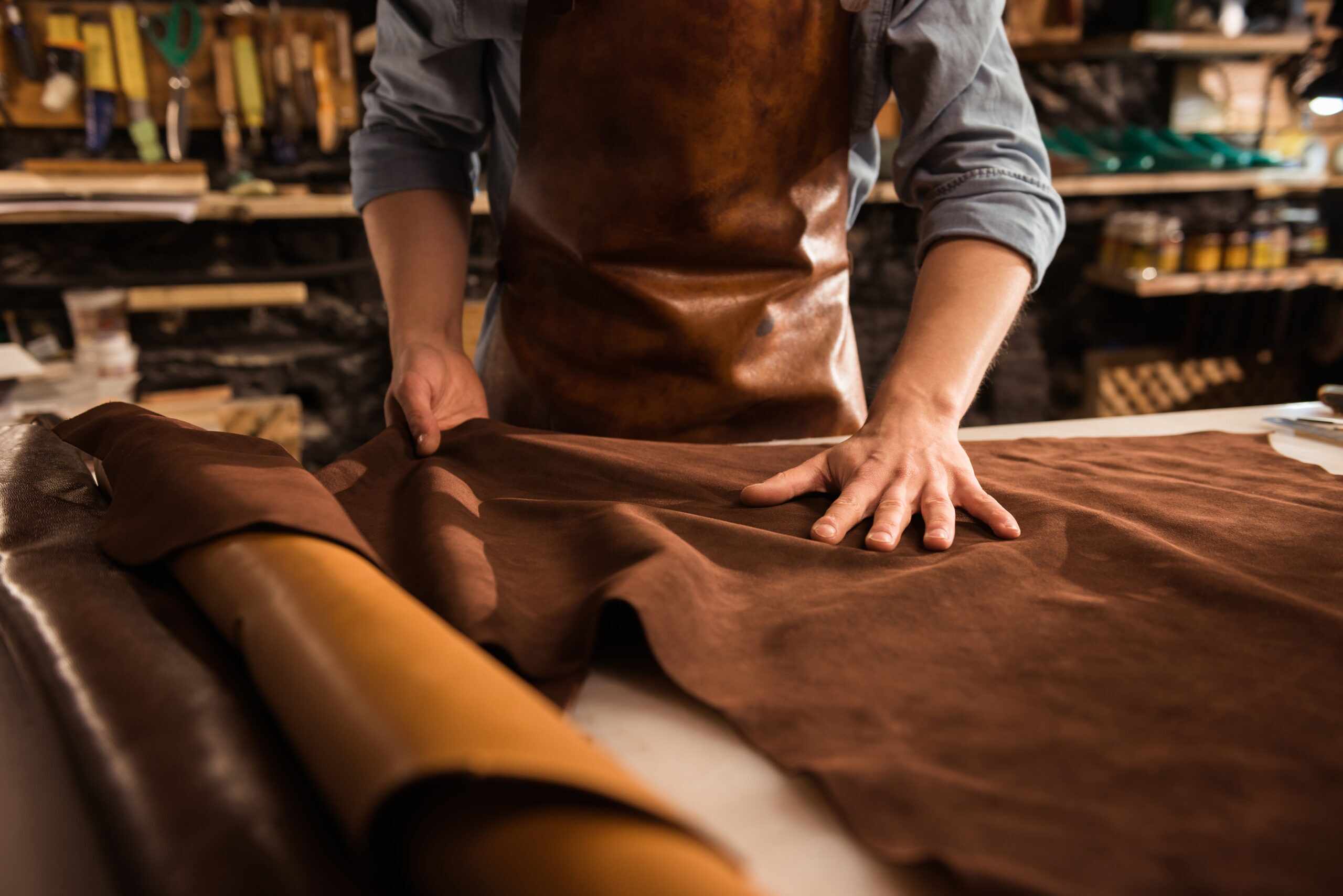 close up cobbler working with leather textile scaled 1